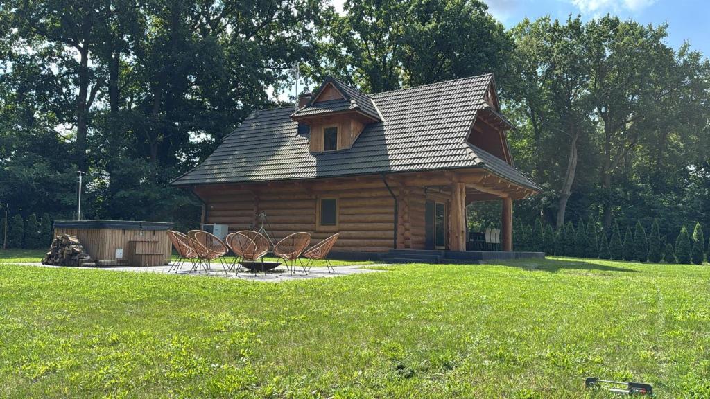 una baita con sedie in un campo di Stawowy Zakątek a Ruda Milicka