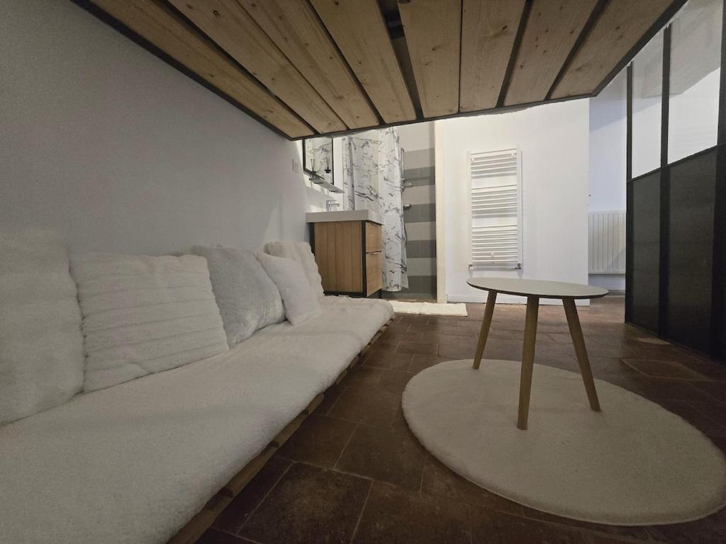 ein Wohnzimmer mit einer weißen Couch und einem Tisch in der Unterkunft le rêve suspendu in Le Mans