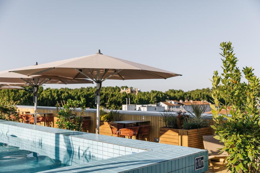 a pool with an umbrella and a table and chairs at The Social Hub Toulouse Extended Stay in Toulouse
