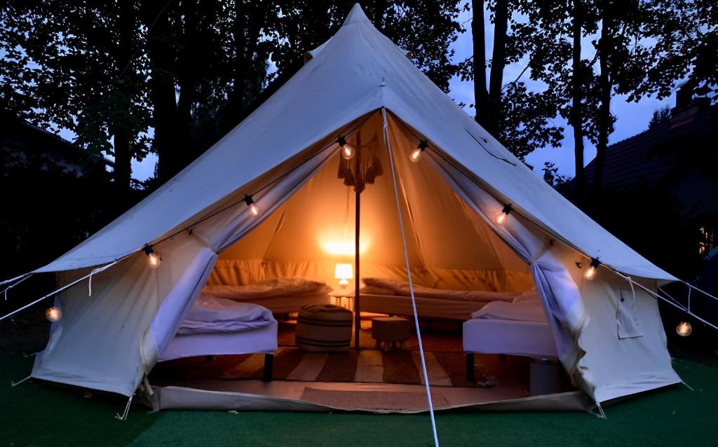 ein weißes Zelt mit Betten darin bei Nacht in der Unterkunft Chill Camp in Giewartów