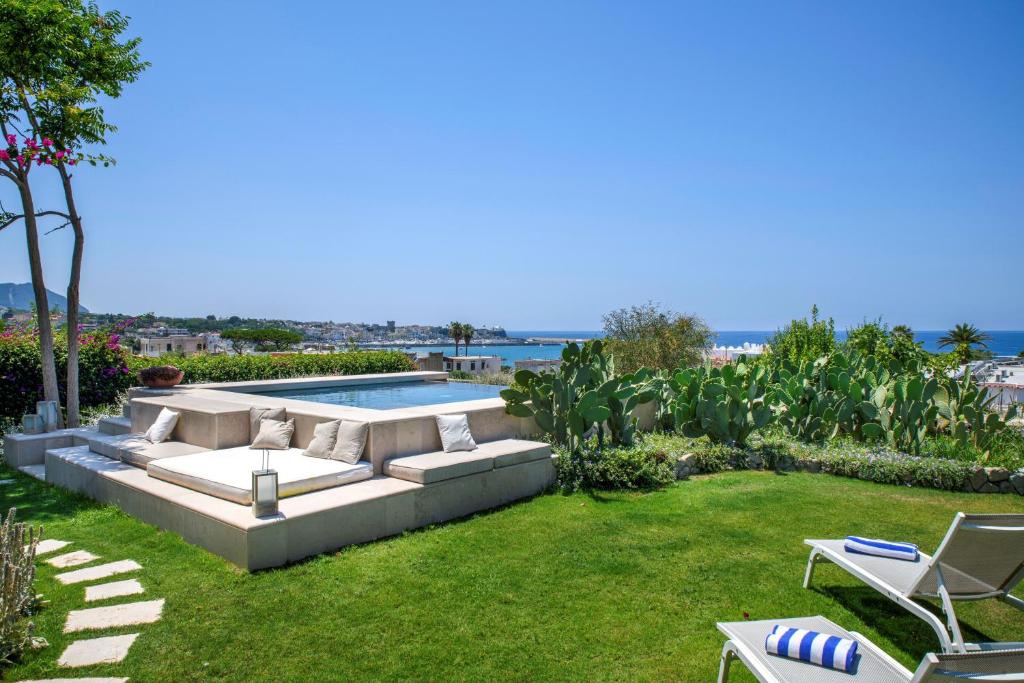 a garden with a couch and a swimming pool at OraBlu Villas in Ischia