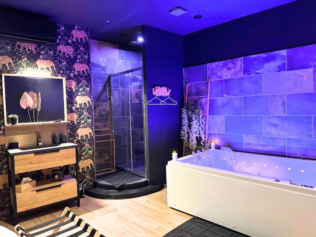 ein lila Badezimmer mit einer Badewanne und einer Dusche in der Unterkunft Escale Singulière - Luxe & balnéo à Sète in Sète