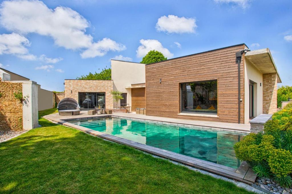 Luxury Villa Orion with heated Pool, Billard في Biéville-Beuville: حمام سباحة في الفناء الخلفي للمنزل