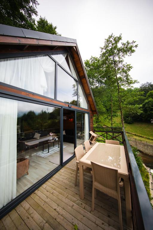 a house with a deck with a table and chairs at Alnada Resort in Düzköy