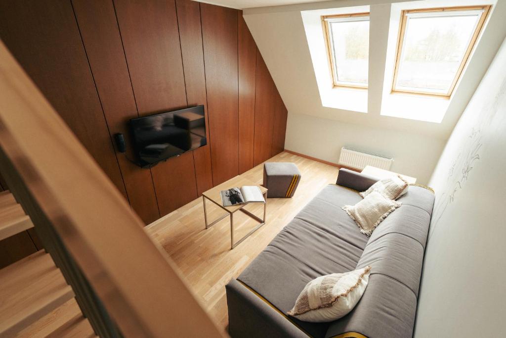 a living room with a couch and a tv at Mana Suites & Sea in Palanga