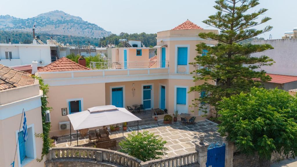 een huis met een patio en een boom bij 1944-Heritage House in Lardos