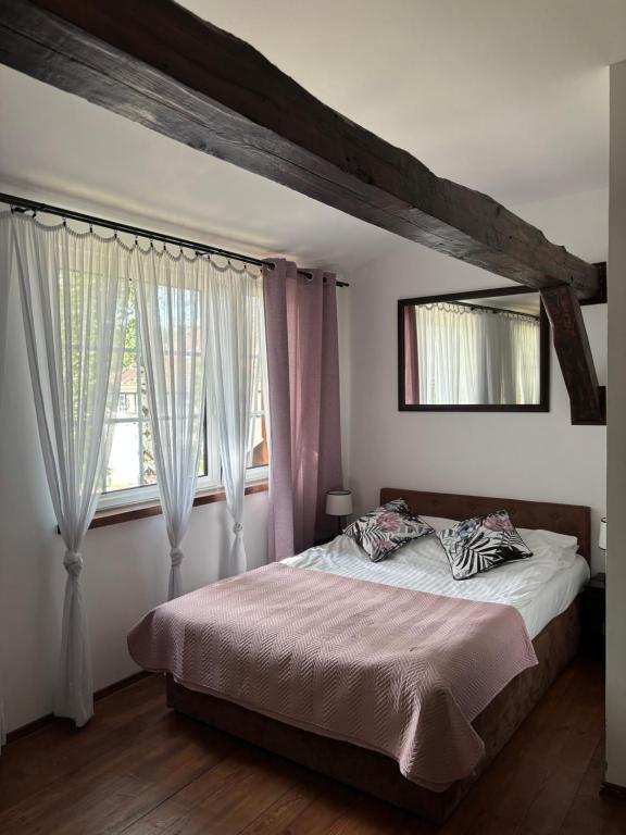a bedroom with a bed and a large window at Ostoja Sawica in Szczytno