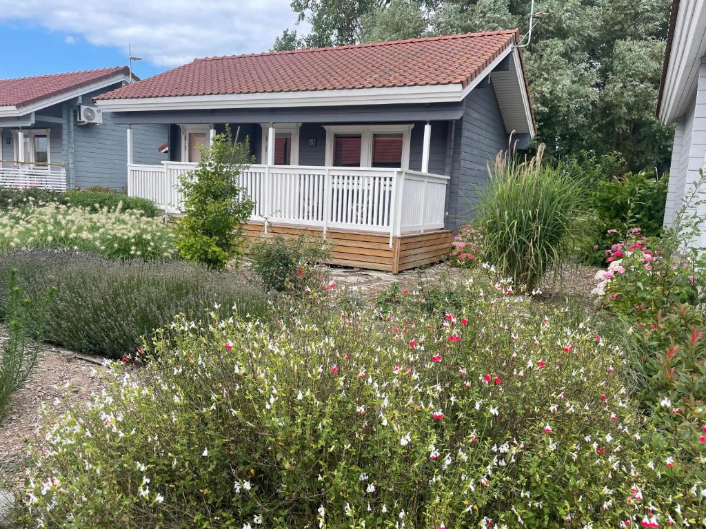 ein kleines Haus mit einem Garten mit Blumen in der Unterkunft cottage le reposant 90 in Bourbourg