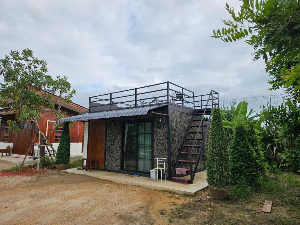 a small house with a staircase in front of it at ฮักจังโฮมสเตย์ ที่พักแม่แตง in Chiang Mai