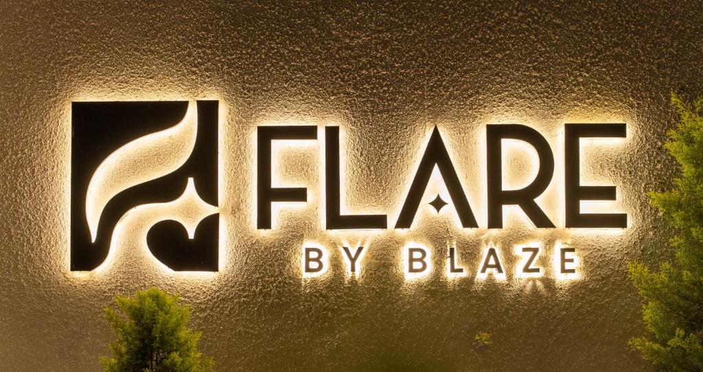 a sign for the batman logo on a wall at Flare By Blaze in Bhopal