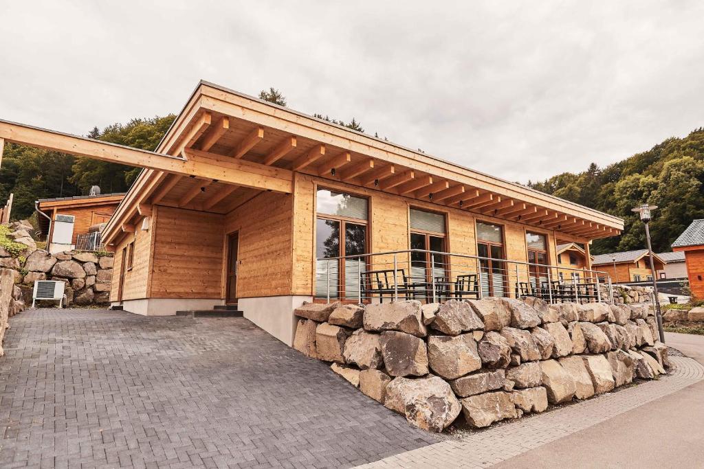 a house with a stone wall in front of it at Wellness Ferienhaus “Lotus II” in Rieden