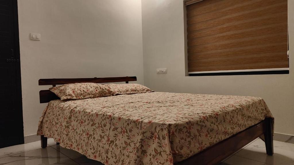 a bedroom with a bed with a wooden headboard at Beach Stay in Kozhikode