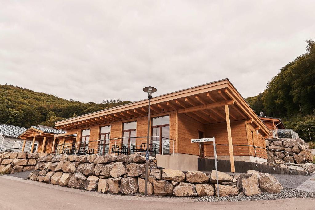 a building with a stone wall in front of it at Wellness Ferienhaus “Lotus I” in Rieden