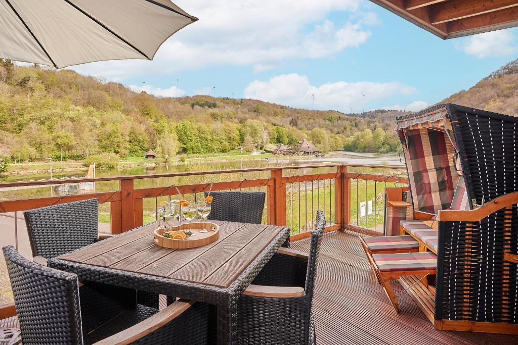 een houten tafel met stoelen en een parasol op een terras bij Ferienwohnung Mila OG in Rieden