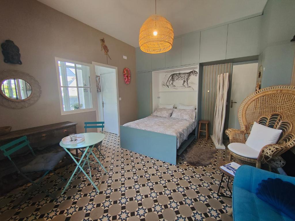 une chambre avec un lit, une table et des chaises dans l'établissement Pépite à 100m de la plage, à Dinard