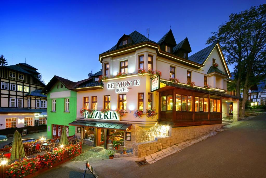 a large building with a sign that reads dinosaur hotel at Hotel pizzeria Belmonte in Špindlerův Mlýn