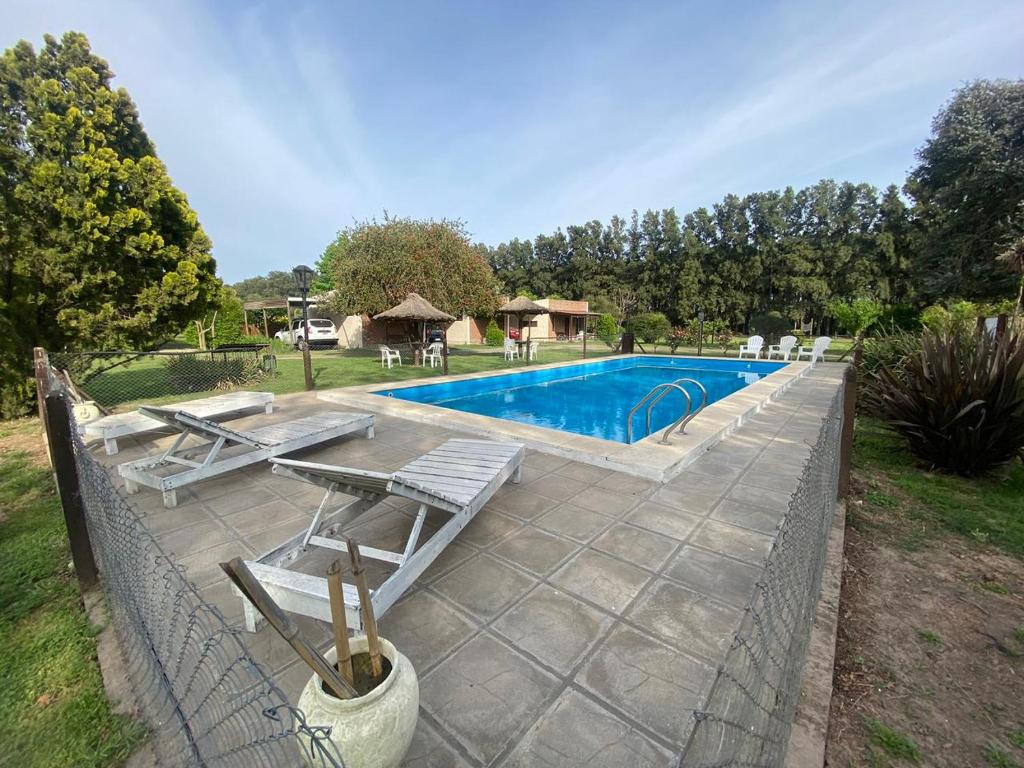 een zwembad met een tafel en stoelen naast een hek bij Posada Rio Tala in Río Tala
