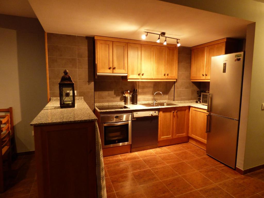 拉伊格萊蘇埃拉德爾西德的住宿－Casa Atheba，厨房配有木制橱柜和不锈钢冰箱。