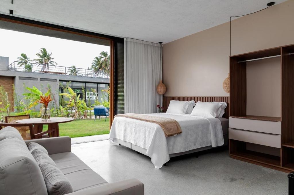 a bedroom with a bed and a large window at Kasa Leme in Tatuamunha