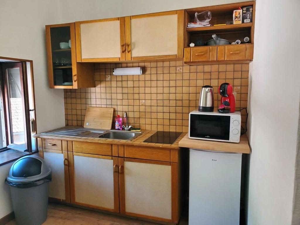 a small kitchen with a sink and a microwave at Appartement entier - cosy et lumineux - Plein centre-ville in Épinal