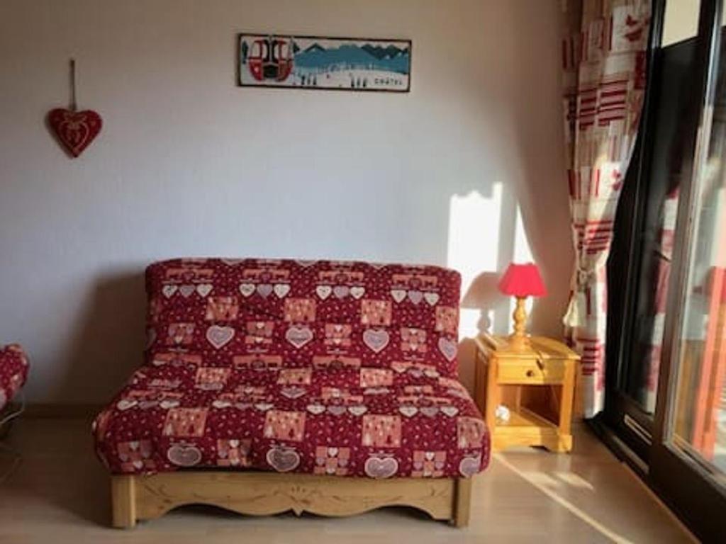 - un canapé rouge dans le salon avec un lit dans l'établissement Studio confortable pour 3 pers. à Châtel avec parking - FR-1-676-214, à Châtel