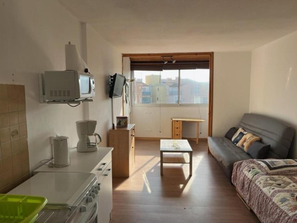 Elle comprend un petit salon doté d'un canapé et d'une télévision. dans l'établissement Studio 5 personnes, plage à deux pas, parking gratuit - FR-1-749-20, au Cap d'Agde