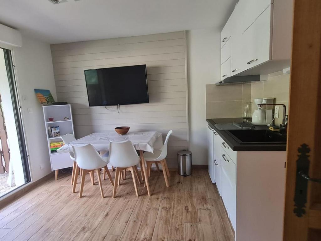 Il dispose d'une télévision et d'une cuisine avec une table et des chaises blanches. dans l'établissement Appartement cosy à Châtel, 100m des pistes, balcon, WiFi, parking, jusqu'à 4 personnes - FR-1-676-105, à Châtel