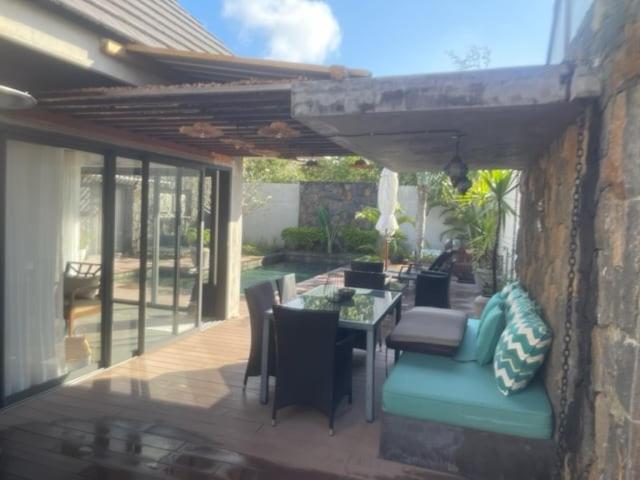 a patio with a table and chairs and a dining room at Villa RayHan in Grand-Baie