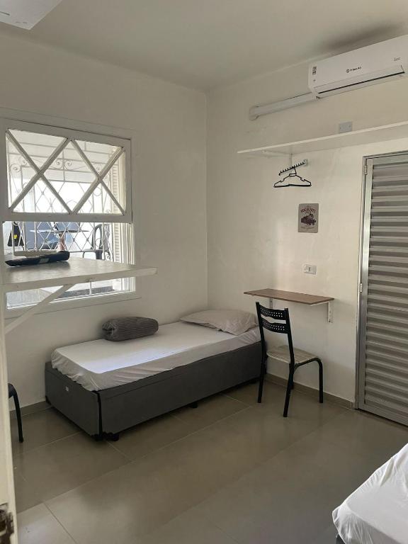 a bedroom with a bed and a desk and a window at SUITE Metro SPExpo Airport CPB in Sao Paulo