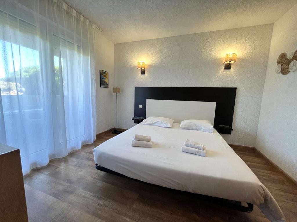 ein Schlafzimmer mit einem großen weißen Bett mit zwei Kissen in der Unterkunft Joli studio avec balcon vue mer à St Florent 140 in Saint-Florent