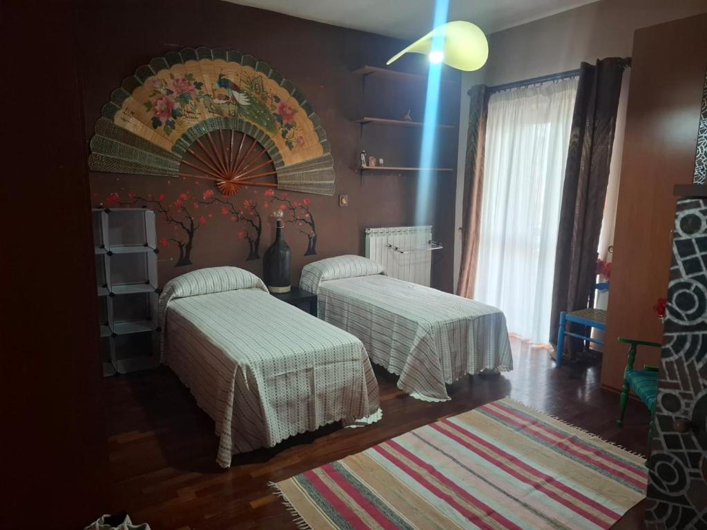 a bedroom with two beds and a wall with a mural at La Casa di Piero in SantʼAngelo