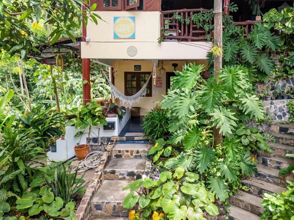 a house with a bunch of plants in front of it at Slow-Down Homestay 2 in Koh Tao