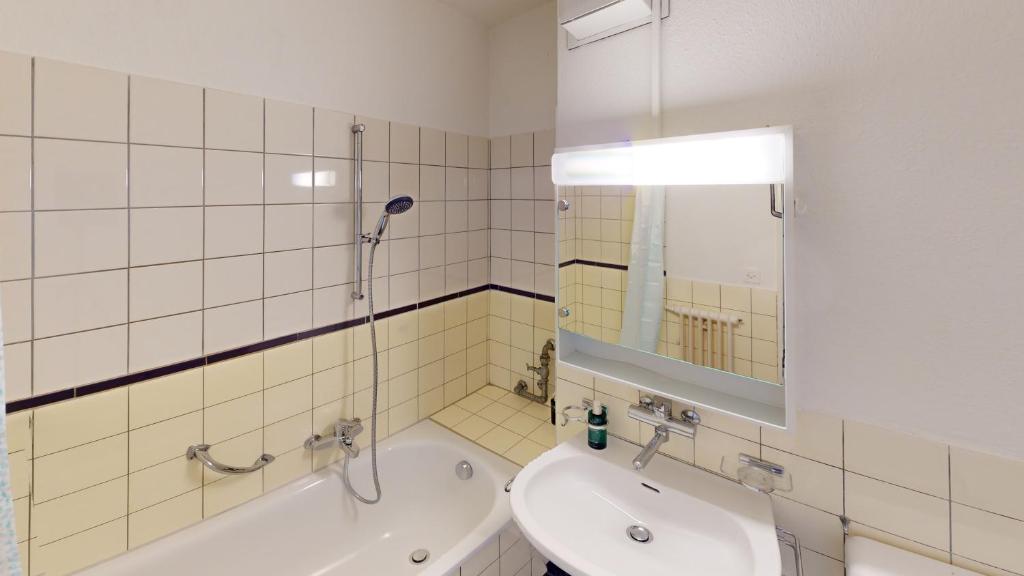 un bagno con vasca, lavandino e specchio di Basic & Simple on Langgrütstrasse a Zurigo
