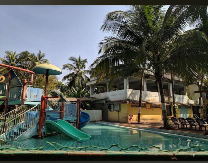 einen Pool mit Rutsche und Spielplatz in der Unterkunft Kalyani Village Resort in Khanivde