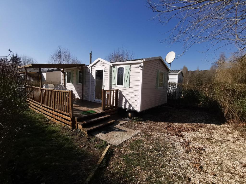 a small white house with a wooden fence at Mobilhome 6P 3CH Nature & Sport - Ivry-La-Bataille - Séjour Normandie in Ivry-la-Bataille