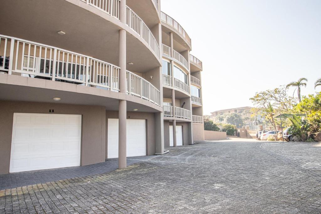 a building with two garage doors on a street at Praslin 4 in Margate