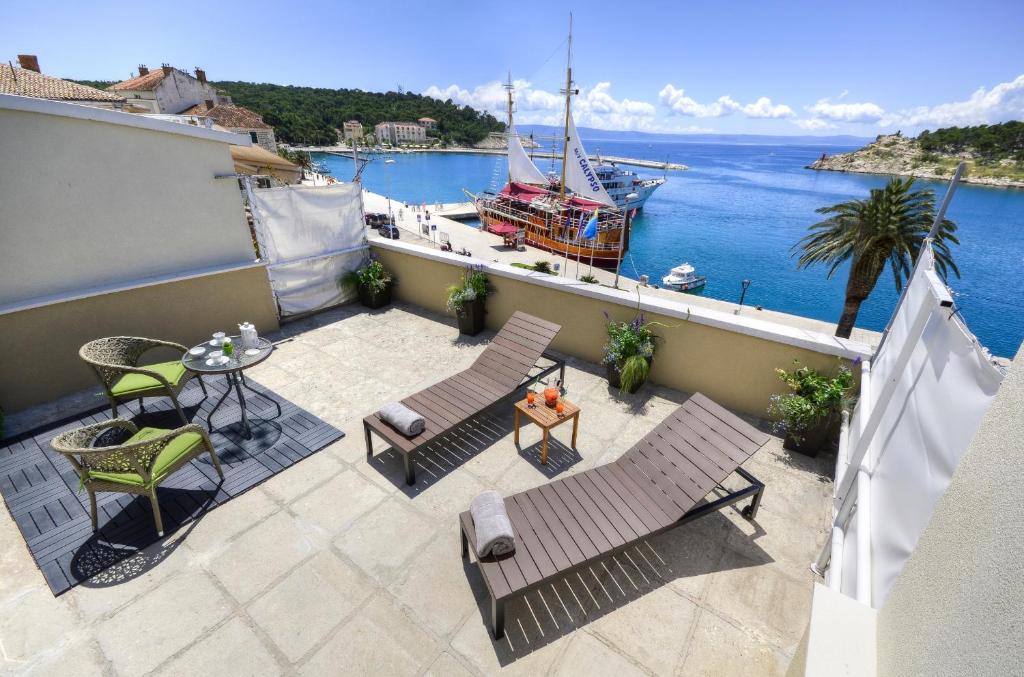 einen Balkon mit Stühlen, einem Tisch und einem Boot in der Unterkunft Apartment Mare in Makarska