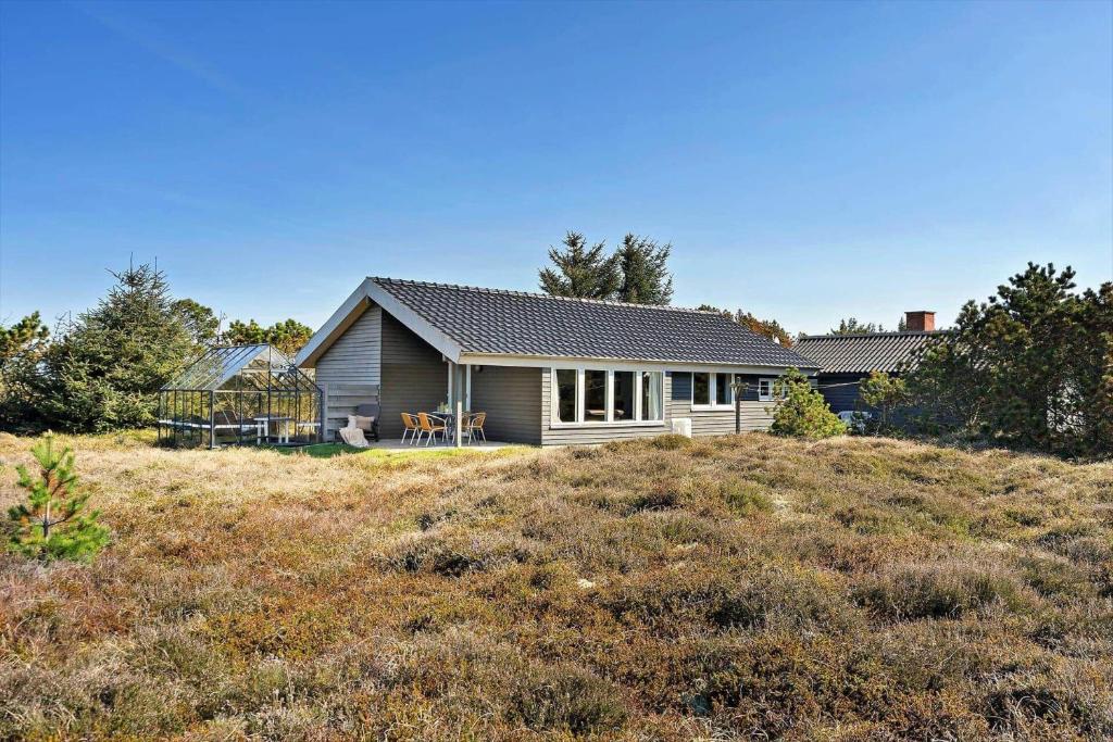 a house on top of a hill with a field at 6623-Hvide-Sande-Bilbergsvej-18 in Bjerregård