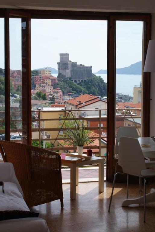 a living room with a table and a view of a city at Il Terrazzo Sul Castello in Lerici