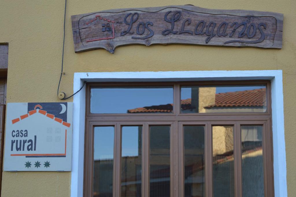 a sign on the side of a building with a window at Casa Rural Los Lláganos in Villaturiel