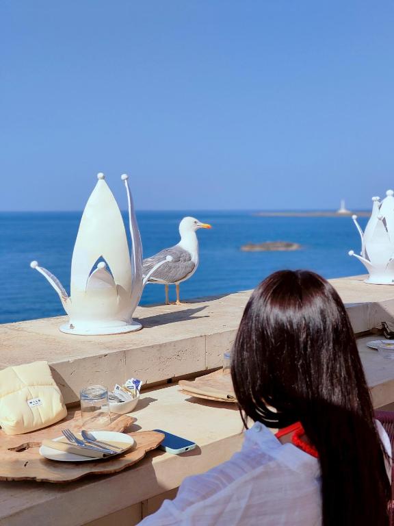 a woman sitting at a table with a bird sculptures at I Bastioni San Domenico - Boutique Hotel in Gallipoli