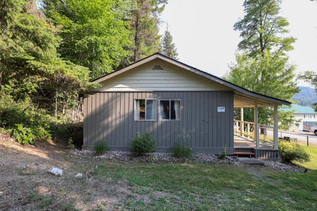 una piccola capanna con un portico in un cortile di Wilderness West Resort Cabin 3 a Colville