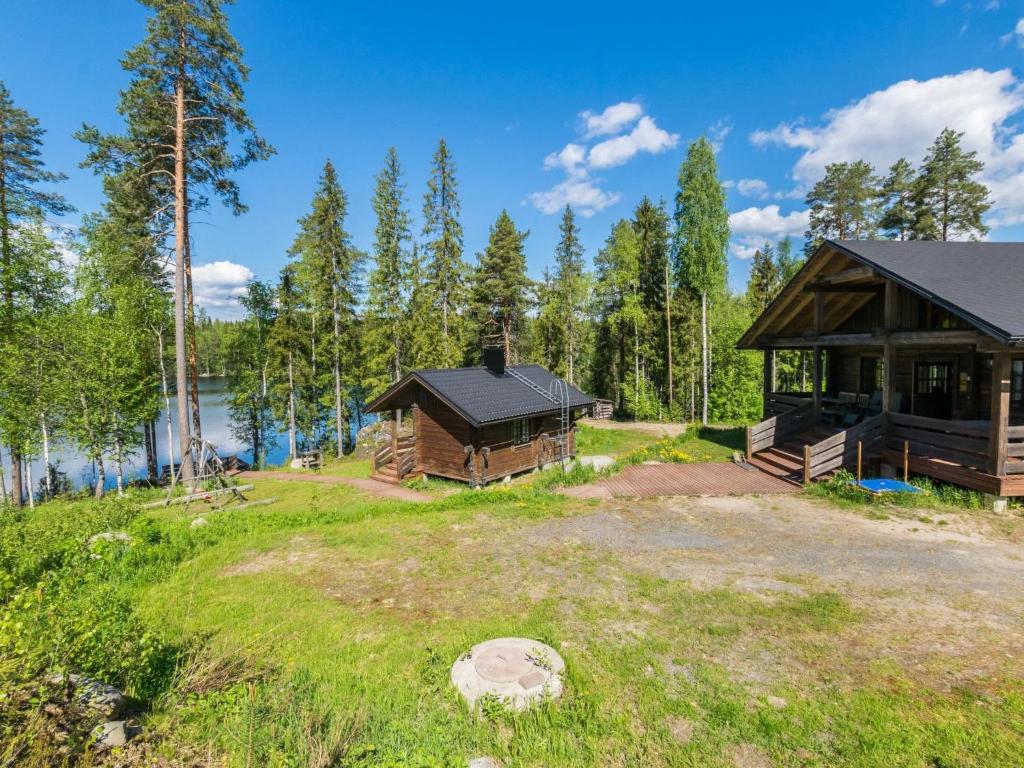 een hut in een veld naast een meer bij Holiday Home Iltaranta by Interhome in Jyväskylä