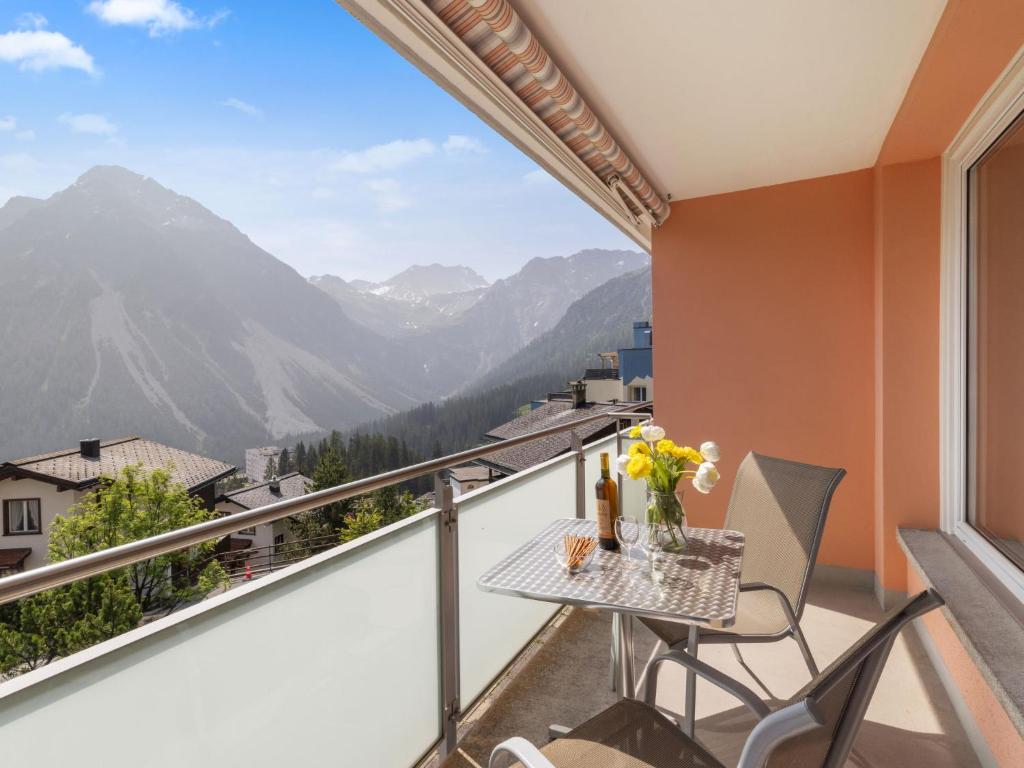 a balcony with a table and chairs and a view of mountains at Apartment Promenade Apt 109 & Apt 110 by Interhome in Arosa