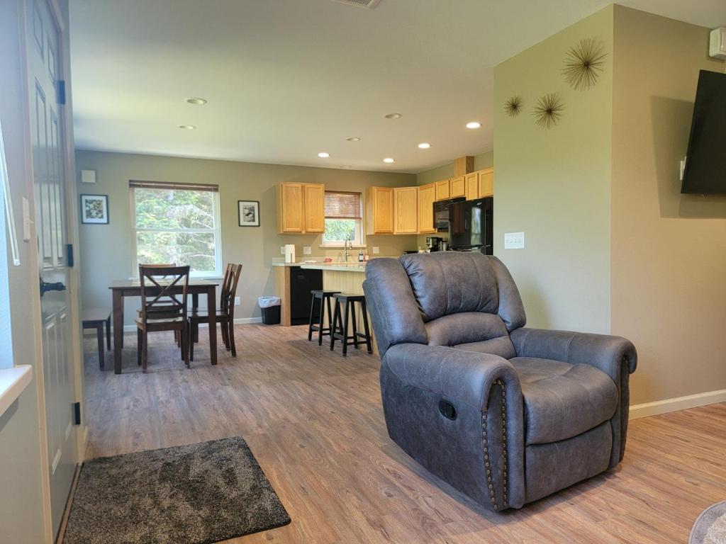 a living room with a leather chair and a kitchen at Lakeshore Lodging Apartment H in Homer