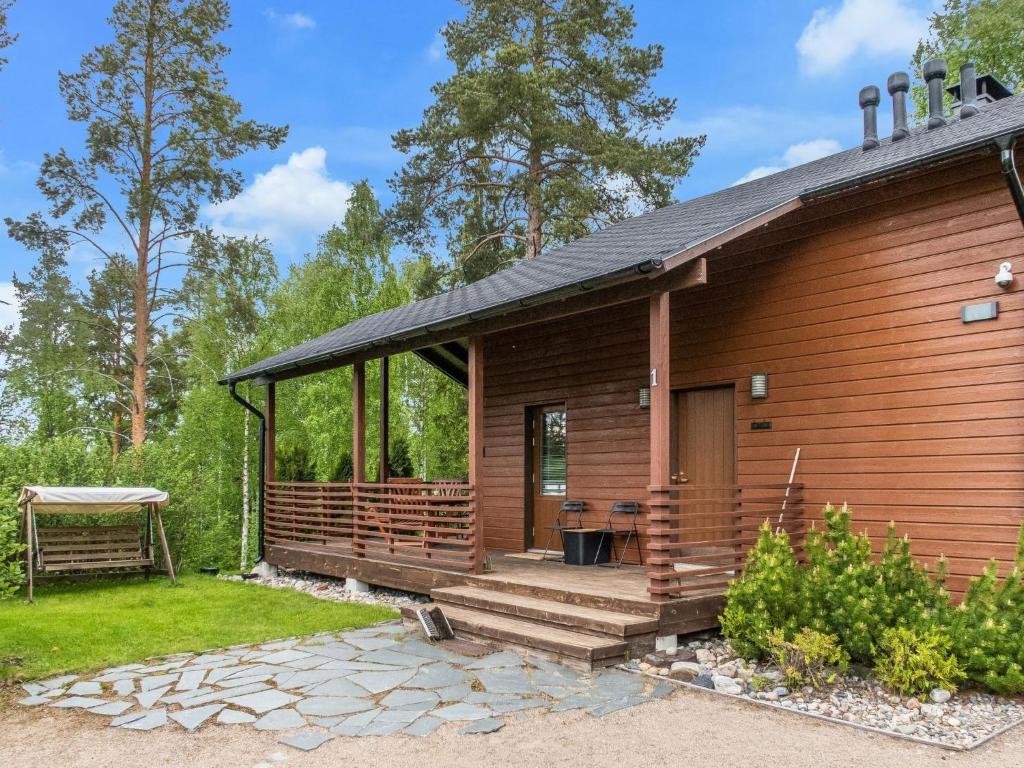 eine Holzhütte mit einer großen Veranda und einer Terrasse in der Unterkunft Holiday Home Kanervarinne by Interhome in Vuokatti