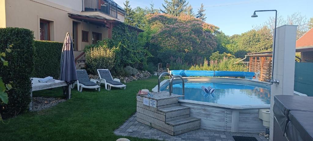 a swimming pool in the yard of a house at Marianna Apartman in Gyenesdiás
