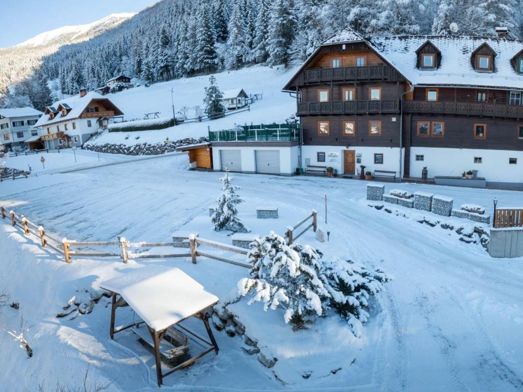 a snow covered yard in front of a large building at Apartment Donnersbach by Interhome in Donnersbach