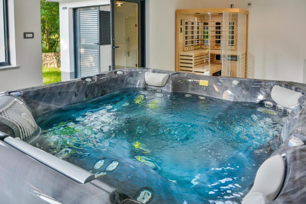 a jacuzzi tub with blue water in it at House MaLa in Senj
