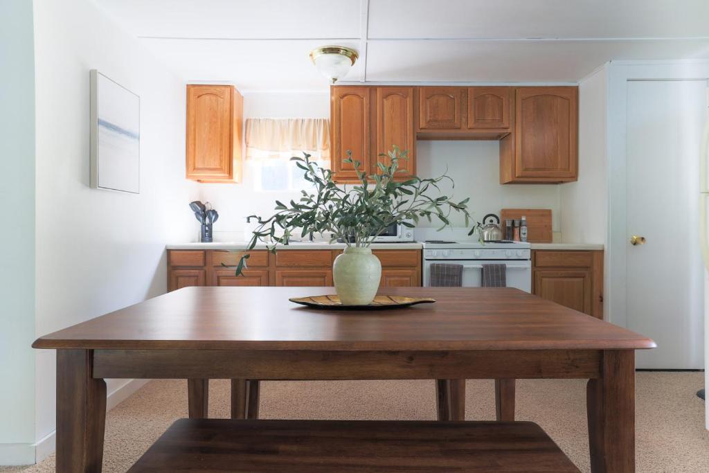 una cucina con tavolo in legno e vaso; di Wilderness West Resort Cabin 2 a Colville